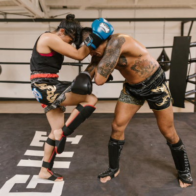 A man and woman kickboxing in the ring.