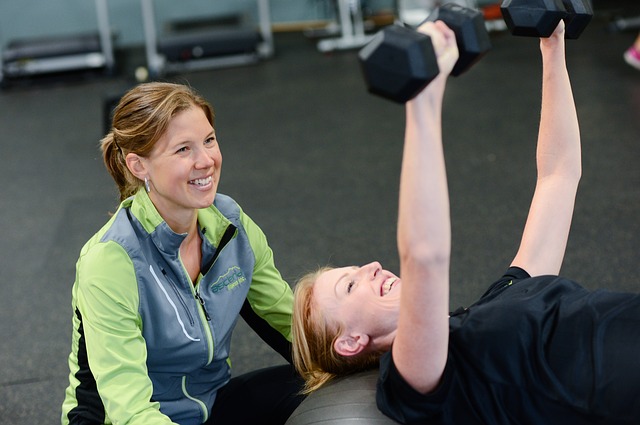 An Ultimate Fitness employee training a client to use weights.